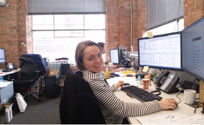 Picture of Maya sitting at her office desk